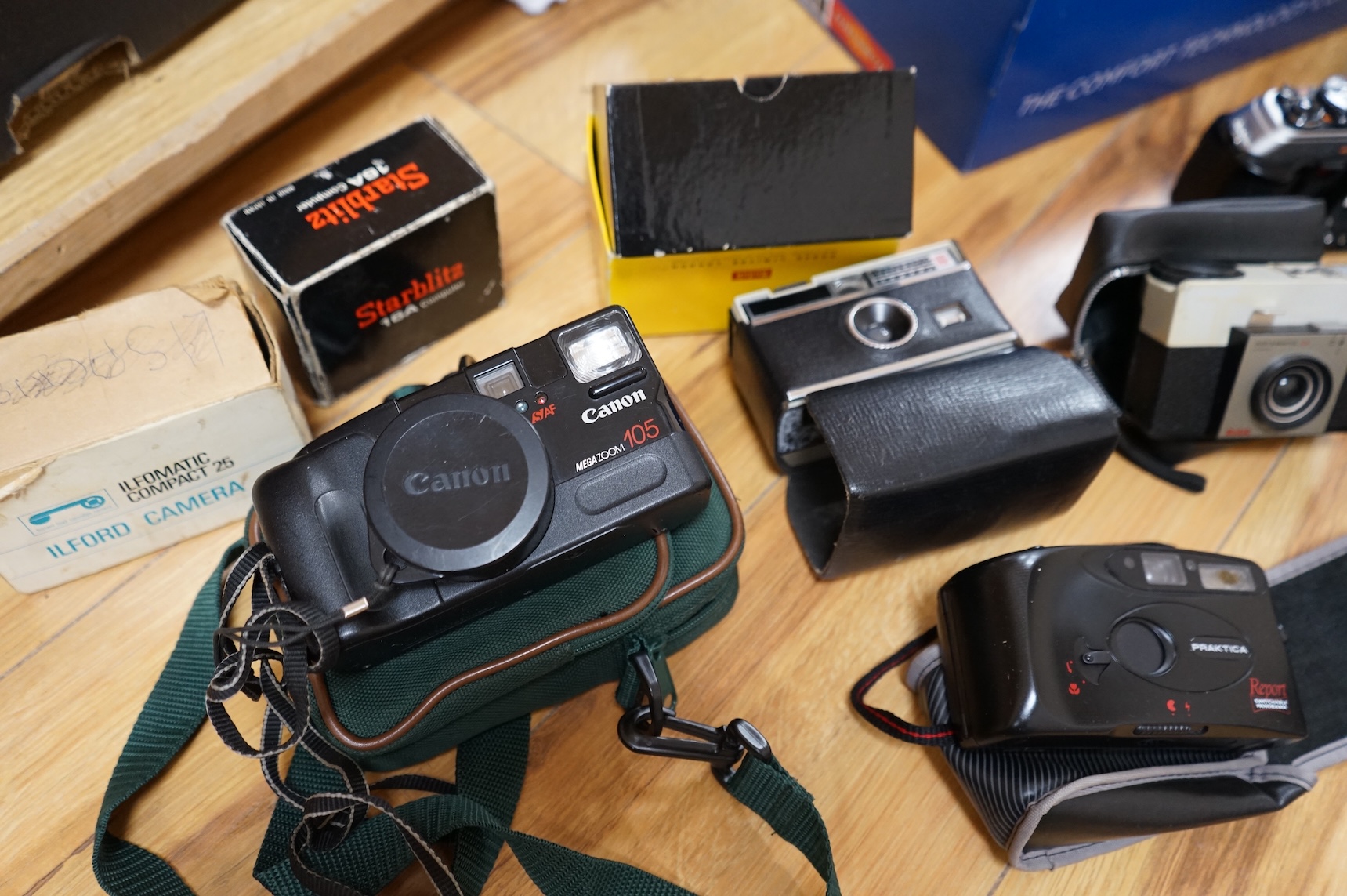 A collection of various cameras and camera equipment to include Konica